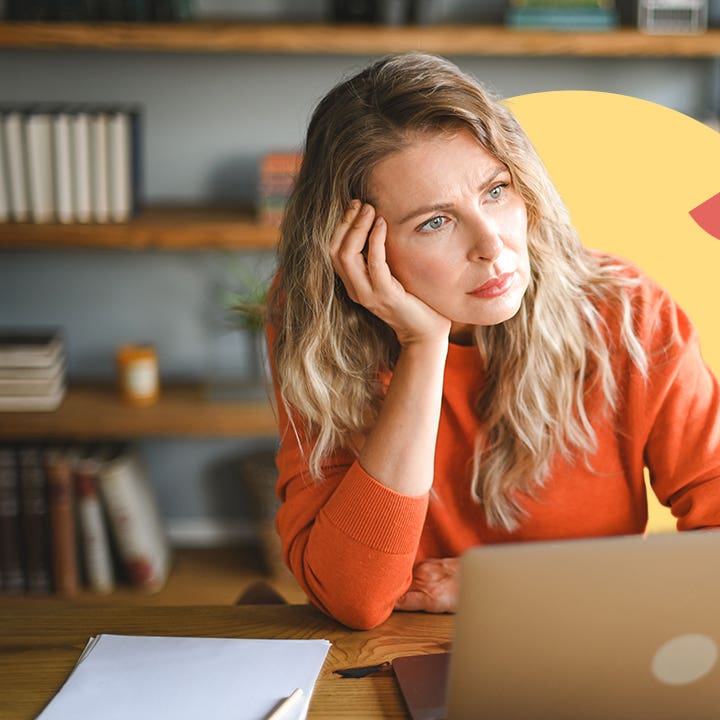 A white woman sitting in front of a laptop at a table looking thoughtful. There is an illustrated element of a yellow circle behind her and a small red half circle on it.